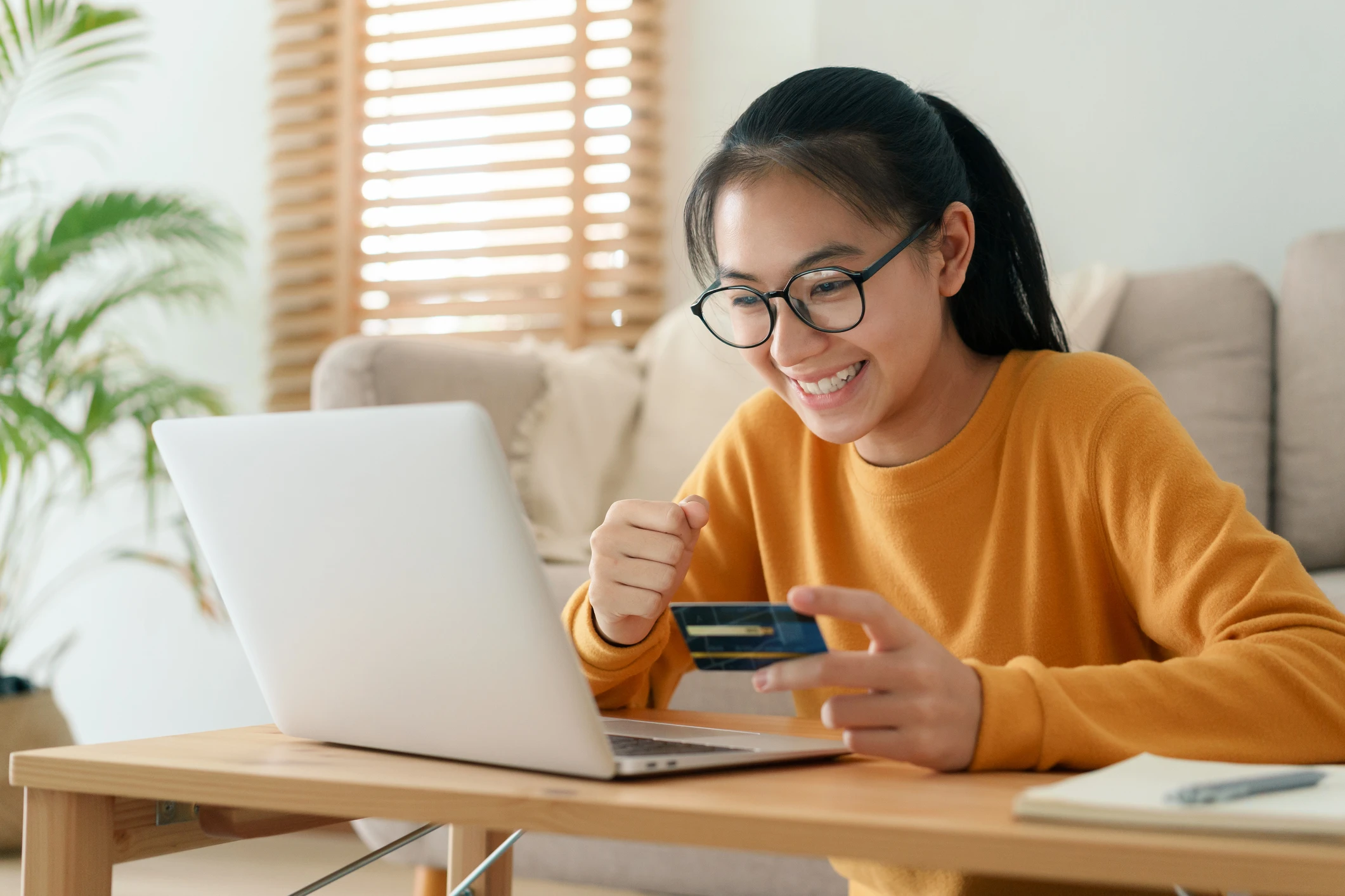 asian girl using debit card and laptop
