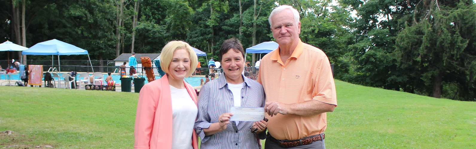 two Amboy Bank employees giving check to Collier employee
