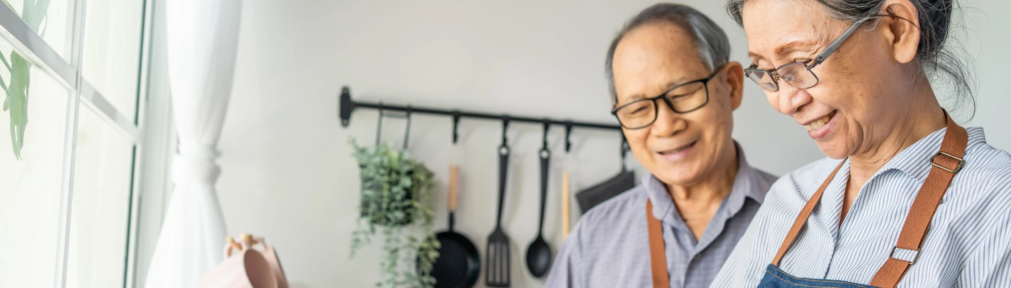 older asian couple cooking at home